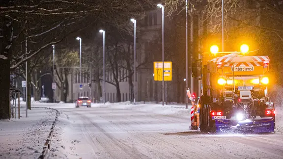 Ein Räumfahrzeug fährt über eine verschneite Straße in Hannover.