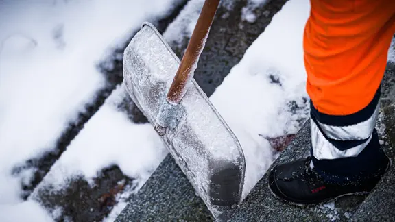 Ein Winterdienst-Mitarbeiter befreit am Morgen eine Treppe in Hannover von Schnee.