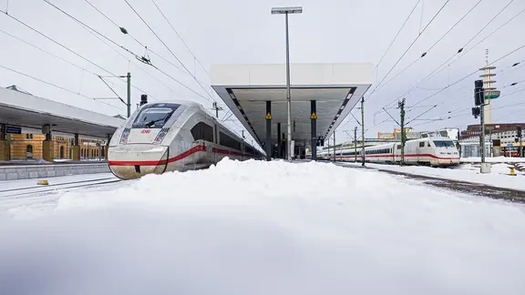 Am Hauptbahnhof in Hannover steht ein ICE an einem verschneiten Bahnsteig.