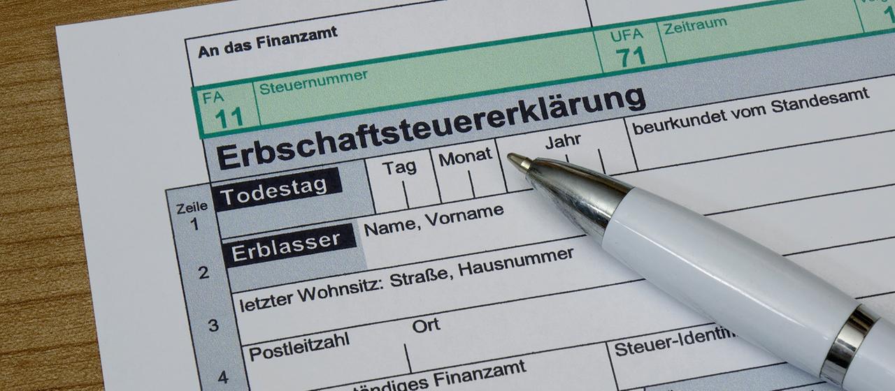 Auf dem Formular einer Erbschaftsteuererklaerung befindet sich ein Kugelschreiber.