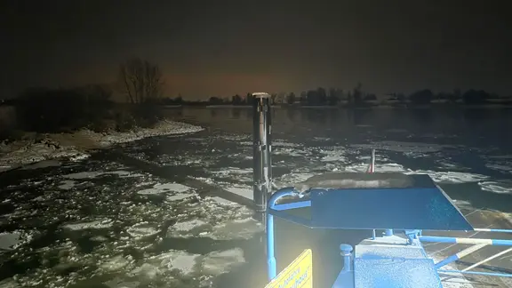 Eisschollen schwimmen auf der Elbe. Eine Fähre bahnt sich ihren Weg hindurch.