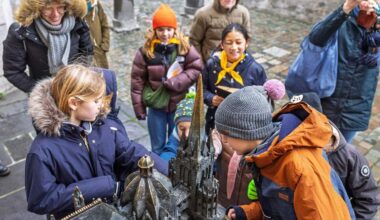 Anfassen erlaubt: Die Kinderdomführerinnen Lily und Marie (gelbe Halstücher, v. l.) zeigen ihrem Publikum bei ihrer Tour auch das bronzene Dommodell neben dem Hauptportal.