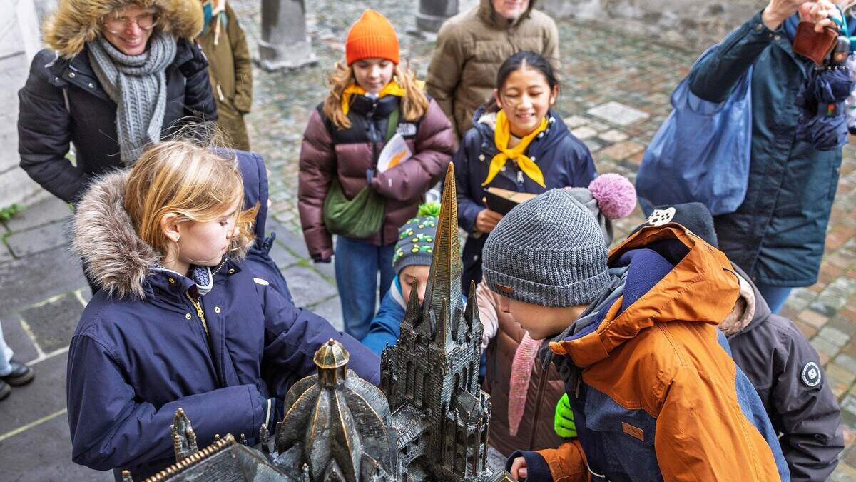 Anfassen erlaubt: Die Kinderdomführerinnen Lily und Marie (gelbe Halstücher, v. l.) zeigen ihrem Publikum bei ihrer Tour auch das bronzene Dommodell neben dem Hauptportal.