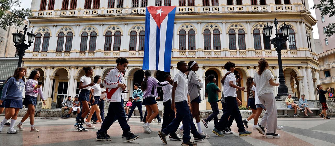 Menschen gehen in Havanna an einem Gebäude mit der kubanischen Flagge vorbei. | EPA Menschen gehen in Havanna an einem Gebäude mit der kubanischen Flagge vorbei.