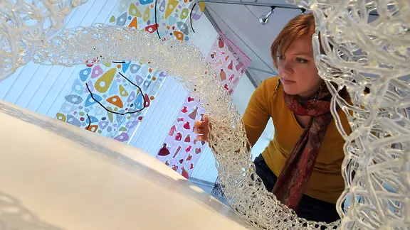 Frau betrachtet Glasskulptur