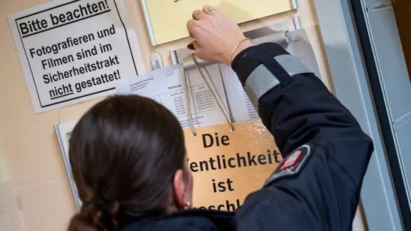 Ein Schild mit der Aufschrift "Die Öffentlichkeit ist ausgeschlossen" wird im Landgericht vor einem Sitzungssaal aufgehängt. 