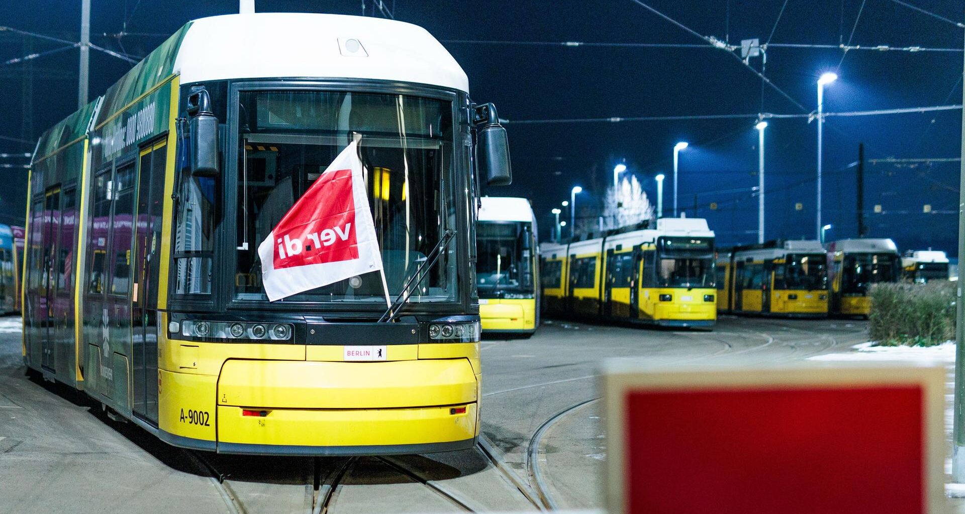 Berlin: Eine Fahne der Gewerkschaft Verdi weht an einer Straßenbahn der Berliner Verkehrsbetriebe BVG hinter der geschlossenen Ausfahrt im Betriebshof Lichtenberg.