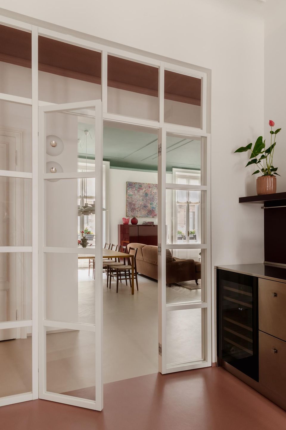 Eine Glastür zwischen Wohn- und Essbereich und dem Flur