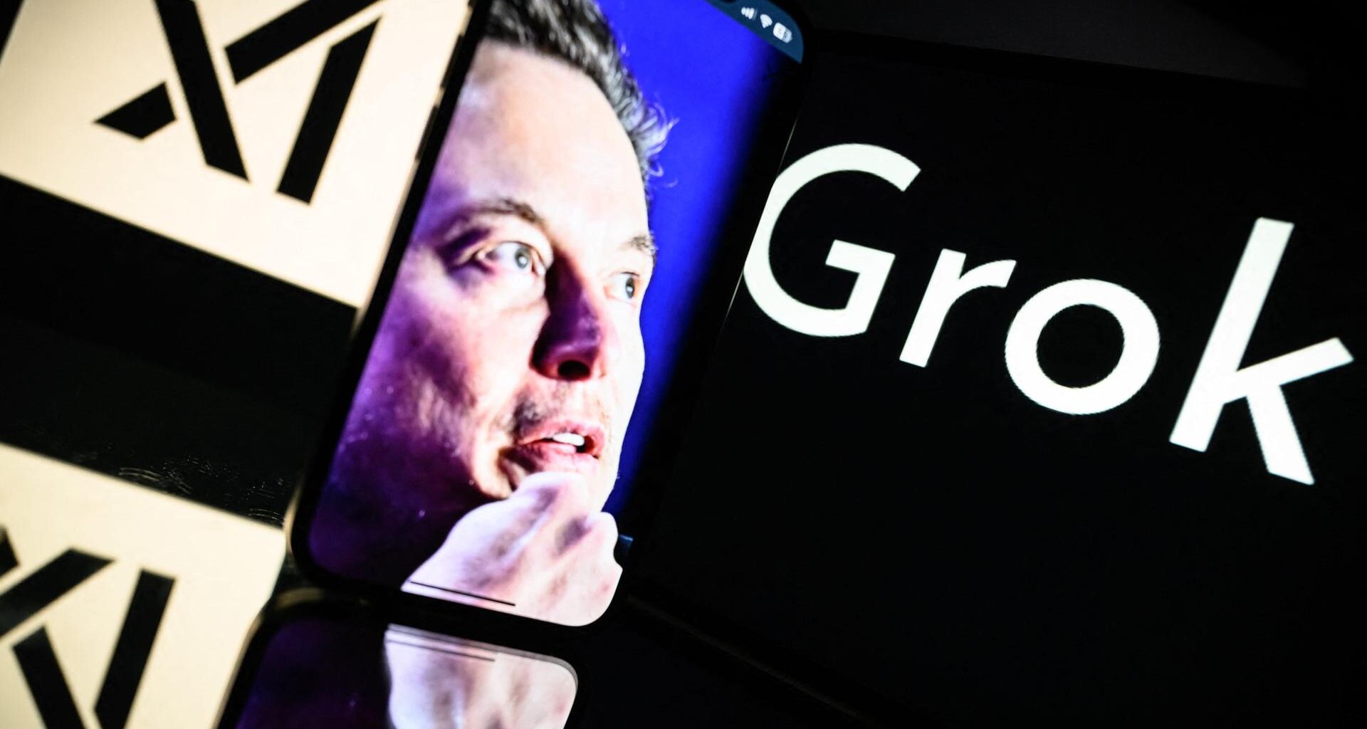Zu sehen ist der Schriftzug "Grok" neben einem Portait Foto von Elon Musk mit nachdenklicher Mimik