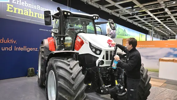 Auf der Grünen Woche wird ein Trecker geputzt.