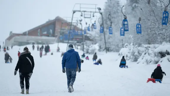 Wintersportler sind in Torfhaus am Rodellift "Brockenblick" auf einer Schlittelpiste unterwegs. | Swen Pförtner/dpa +++ dpa-Bildfunk +++ Wintersportler sind in Torfhaus am Rodellift "Brockenblick" auf einer Schlittelpiste unterwegs.