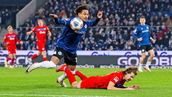 John Tolkin (r.) von Holstein Kiel im Duell mit Arminia Bielefelds Monju Momuluh 