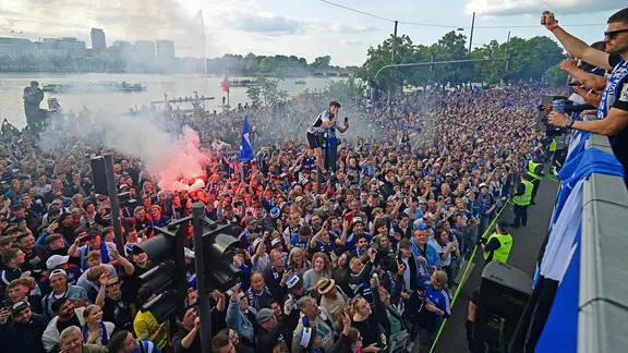 Ein Bus mit HSV-Spielern wird von Fans begleitet.