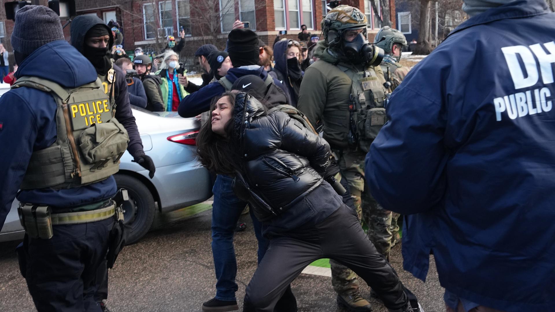 Eine Frau in Minneapolis wird von Beamten der US-Migrationsbehörde ICE aus ihrem Auto gezerrt.