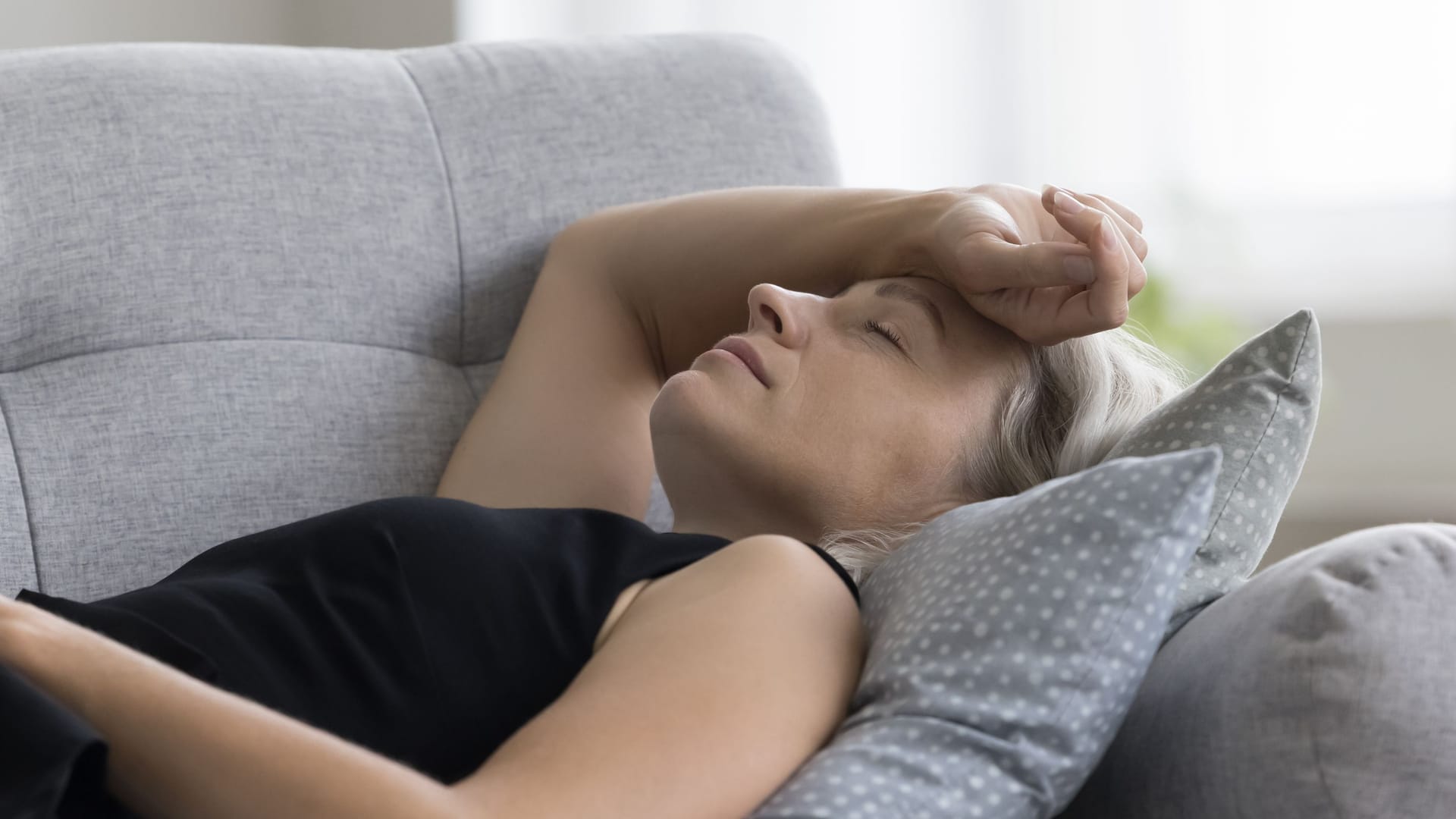 Eine Frau liegt auf dem Sofa