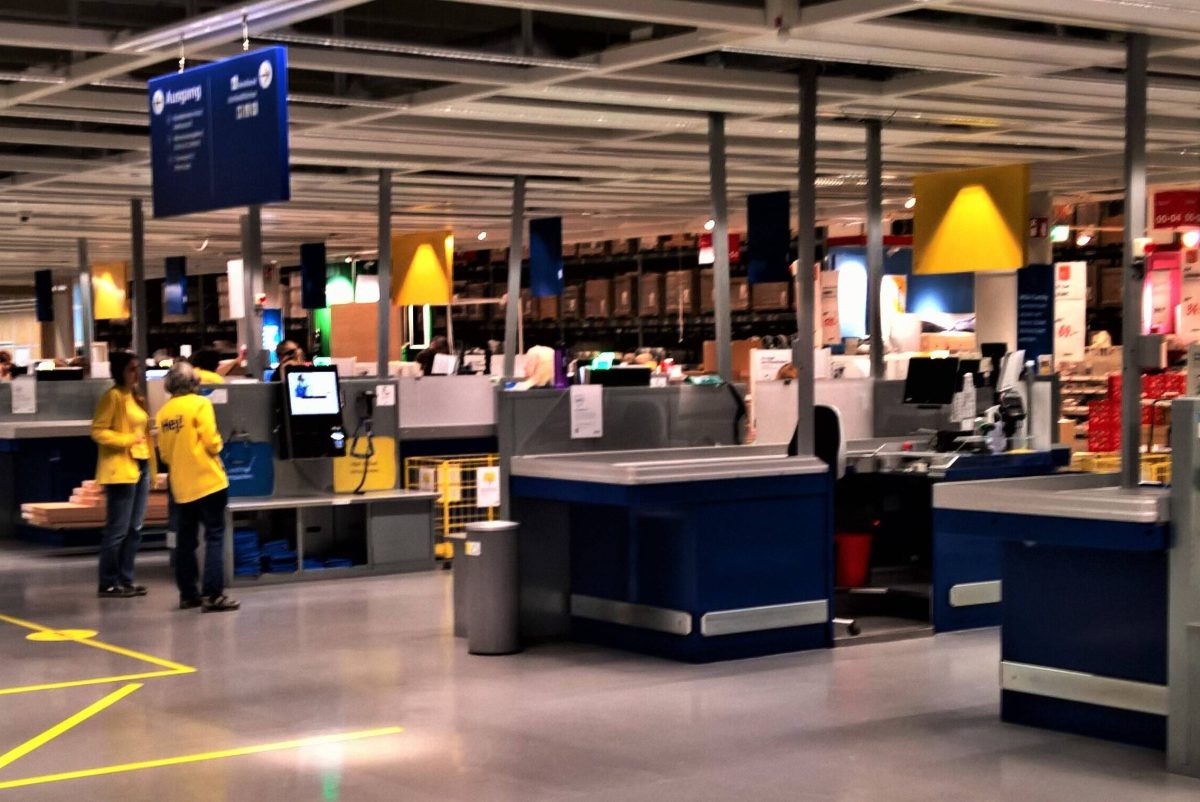 Ikea-Mitarbeiter stehen an einer leeren SB-Kasse.