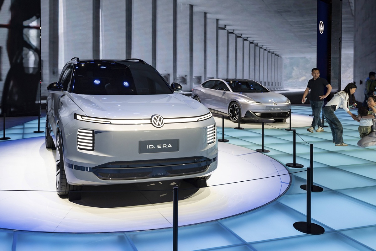 In einer Ausstellungshalle werden zwei Elektroautos ausgestellt.