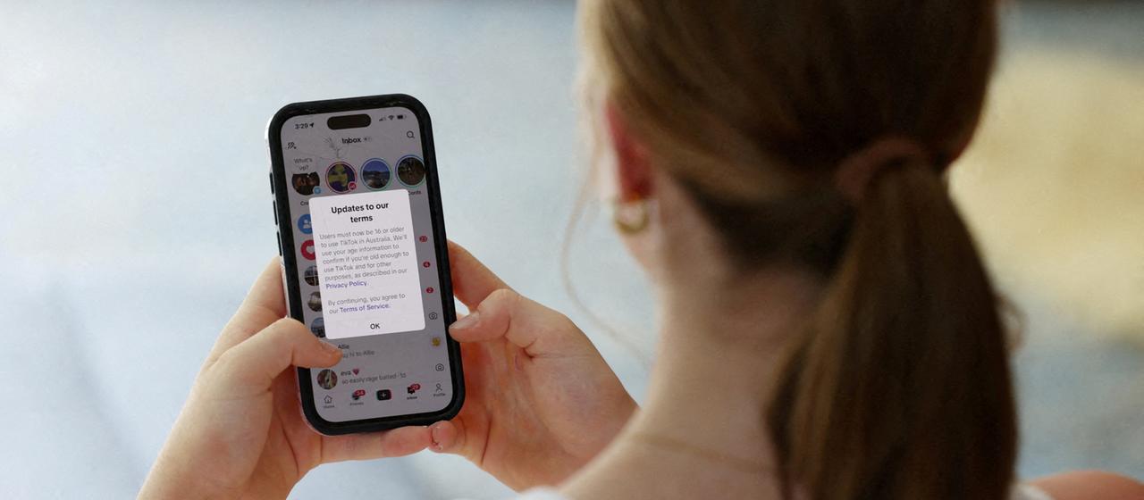 Eine Jugendliche blickt auf ihr Handy.