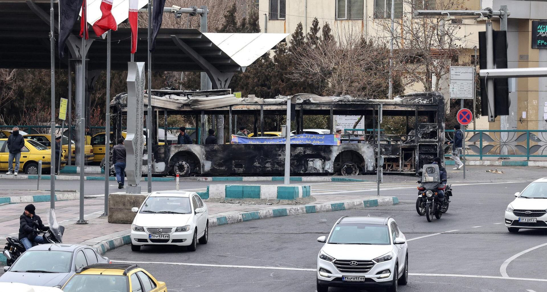 Eine Straßenkreuzung mit wenigen Autos und Menschen in Teheran.