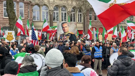 Exil-Iraner protestieren mit Fahnen gegen Gewalt im Iran.