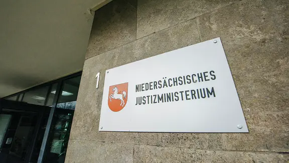 An einem Gebäude hängt ein Schild mit der Aufschrift Niedersächsisches Justizministerium.