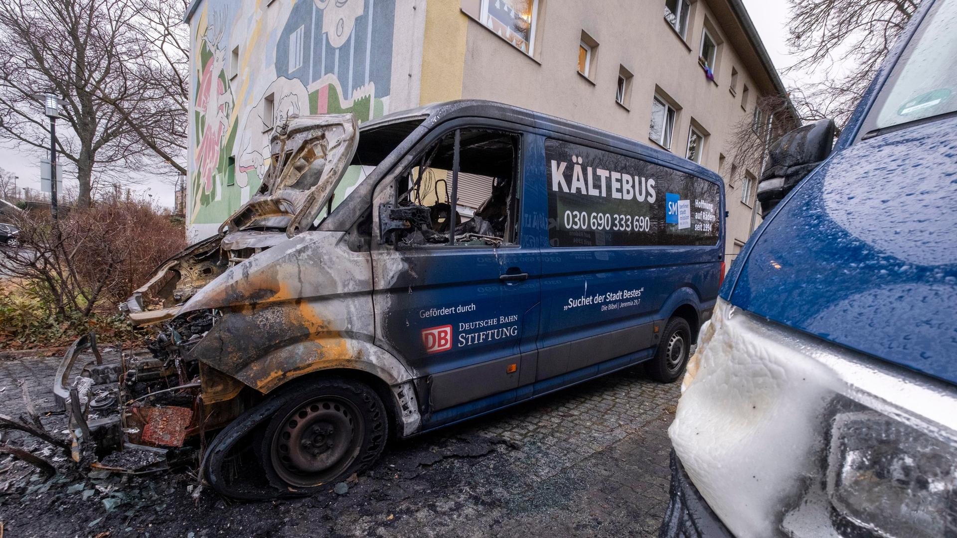 Ein großes Fahrzeug mit der Aufschrift "Kältebus" und einem ausgebrannten Vorderteil an einer Straße. Ein großes Fahrzeug mit der Aufschrift "Kältebus" und einem ausgebrannten Vorderteil an einer Straße.