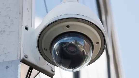 Eine Überwachungskamera hängt an einem Gebäude