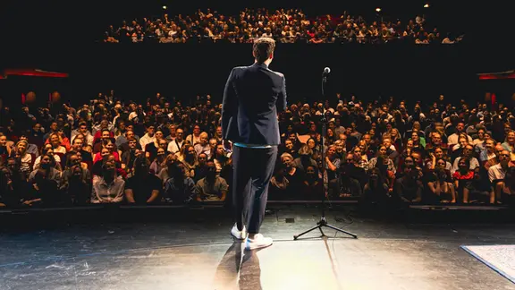 Ein Mann steht vor einem Publikum | Jan Brandes Ein Mann steht vor einem Publikum