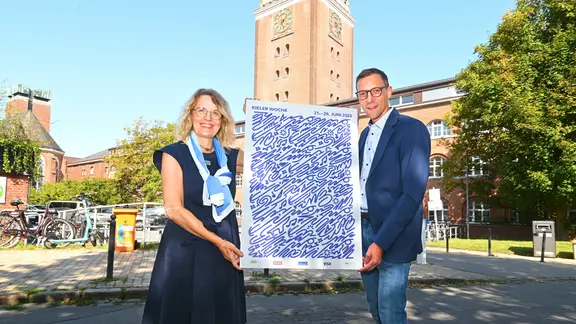 Die zweite stellvertretende Stadtpräsidentin der Landeshauptstadt Kiel, Antje Möller-Neustock, und der Leiter des Kieler-Woche-Büros, Philipp Dornberger präsentieren das Kieler Woche Design für 2025.
