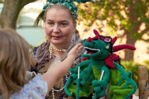 Frau mit Drachen-Handpuppe