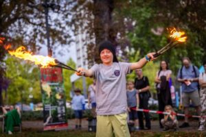 Kind führt eine Feuershow mit Fackeln vor.