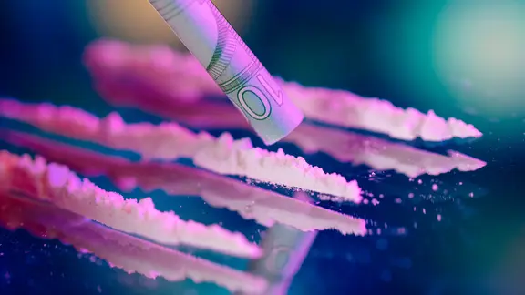 Nur in Bremen, Hamburg und Berlin waren mehr Menschen wegen Kokainmissbrauchs in Behandlung. | picture alliance / Geisler-Fotopress, Christoph Hardt Aufgereihtes Kokain, darüber ein aufgerollter Geldschein.