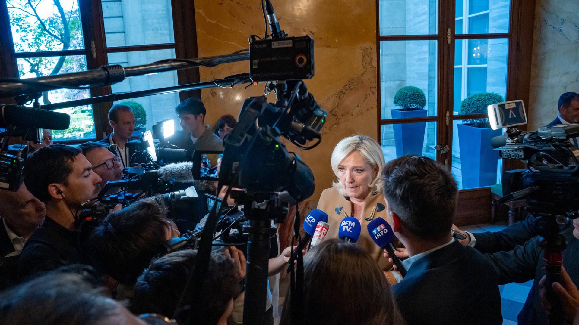 Marine Le Pen, die heutige Fraktionschefin des Rassemblement National (RN), wird von Journalisten und Kameras im Korridor der Nationalversammlung umringt. Paris, 20. Mai 2025