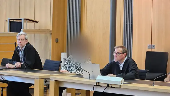 Das angeklagte Ehepaar sitzt mit den Verteidigern Volker Wulf (l.) und Andreas Dieler (2.v.r.) sitzen im Landgericht. | dpa-Bildfunk, Christian Brahmann Das angeklagte Ehepaar sitzt mit den Verteidigern Volker Wulf (l.) und Andreas Dieler (2.v.r.) sitzen im Landgericht.