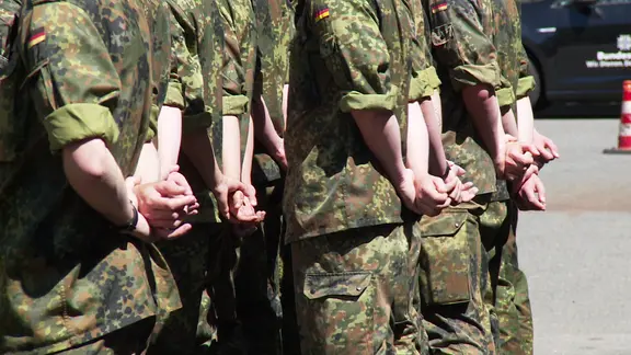 Soldaten stehen auf einem Truppenübungsplatz der Bundeswehr.