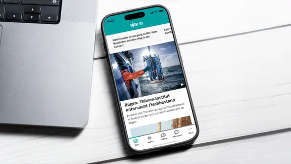 Ein Smartphone zeigt die Startseite der neuen NDR MV App | NDR, IMAGO. / Bihlmayerfotografie Ein Smartphone zeigt die Startseite der neuen NDR MV App