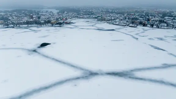 Die Müritz ist vor dem Hafen komplett mit Eis bedeckt. | Jens Büttner/dpa Die Müritz ist vor dem Hafen komplett mit Eis bedeckt.