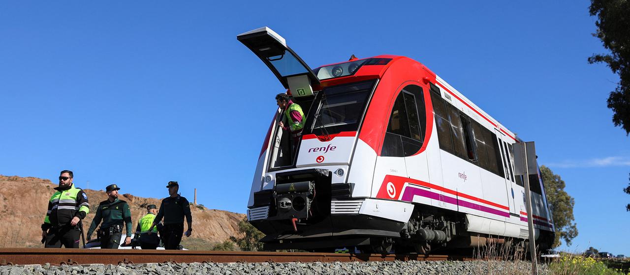 Mitglieder der spanischen Polizei arbeiten neben einem Nahverkehrszug in der Region Murcia.