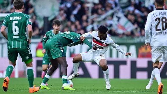 Werder Bremens Victor Boniface (2.vl.) im Zweikampf mit St. Paulis Joel Chima Fujita (3.v.l.).