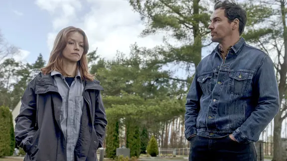 Karoline Schuch und Felix Kramer spielen Roland Voit und Maggie Kring in der Serie "Oderbruch" - ab 20. Februar in der ARD Mediathek. | rbb/ARD Degeto/Syrreal Dogs GmbH/CBS Studios/Stefan Erhard, Karoline Schuch und Felix Kramer als Roland Voit und Maggie Kring in der Serie "Oderbruch" im Wald