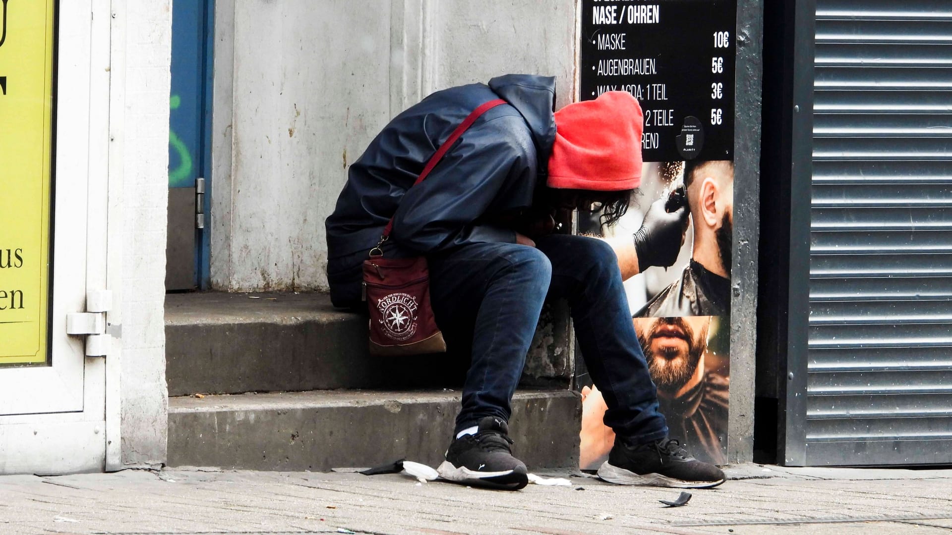 Offenbar drogenabhängiger Mann an einer Straße (Symbolfoto): In Köln streitet am über den Umgang mit der Drogenszene am Neumarkt.