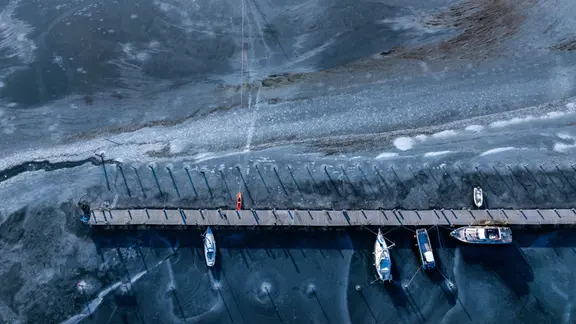 Wenige Boote liegen am Anleger im Hafen an der Wismarbucht im Eis. | Jens Büttner/dpa Wenige Boote liegen am Anleger im Hafen an der Wismarbucht im Eis.