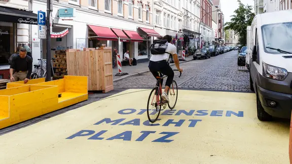 Ein Fahrradfahrer fährt durch eine Straße.