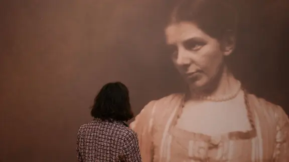 Frau betrachtet Foto von Paula Modersohn-Becker | picture alliance/dpa | Carmen Jaspersen Frau betrachtet Foto von Paula Modersohn-Becker