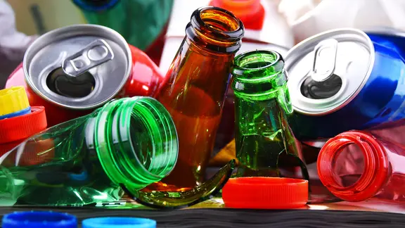 Pfandflaschen und -dosen liegen, zum Teil kaputt, auf einem Haufen.