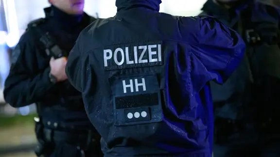 Polizisten in Hamburg stehen im Bereich eines abgesperrten Tatorts. | Jonas Walzberg/dpa, dpa-Bildfunk Polizisten in Hamburg stehen im Bereich eines abgesperrten Tatorts.