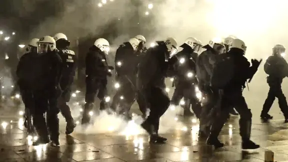 Einsatzkräfte der Polizei inmitten von Pyrotechnik in Hamburg.