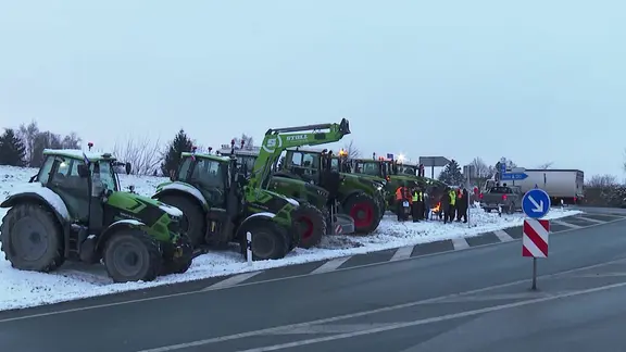 Landwirte protestieren an einer Autobahn-Auffahrt.