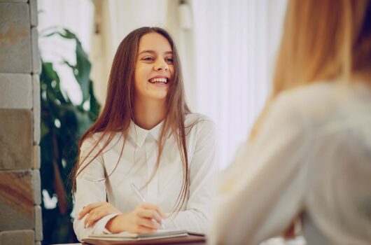 Junge Frau lacht im Beratungsgespräch
