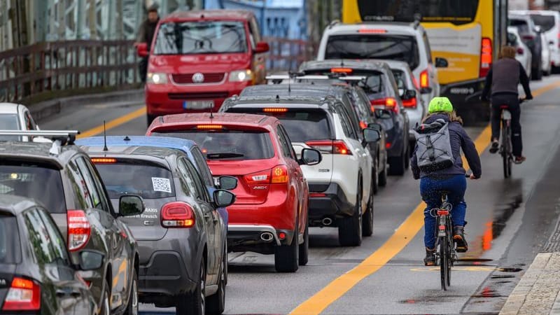 Radfahrer fahren an der Elbbrücke Blaues Wunder auf einem markierten Radweg an Autos im Stau vorbei (Archivbild): In Dresden standen Autofahrer im vergangenen Jahr rund 116 Stunden im Stau.